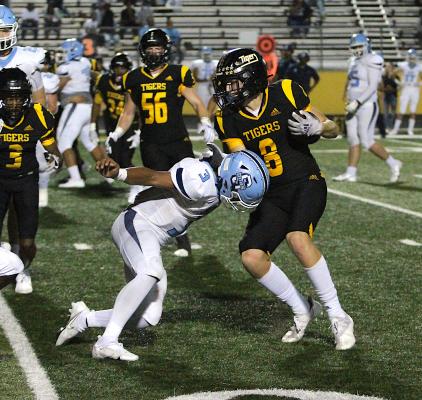 Tiger sophomore Reid Miller delivers a stiff arm to Bulldog defender Trace Holmes in the second half of District 12 action in Sealy Friday night. Miller provided the hosts’ bookending score in the final frame of the Tigers’ 65-33 win over Sweeny. COLE McNANNA