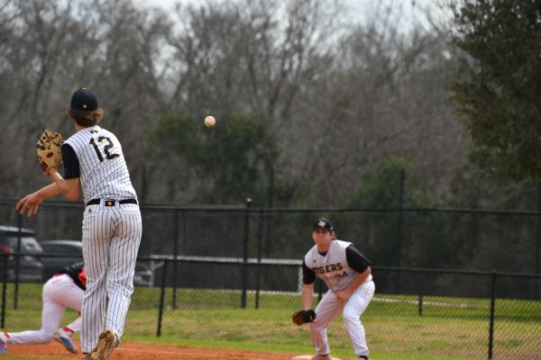 Ty Smitley (#12) throws the ball to his first baseman Tate Anderson to tag the runner for an out.
