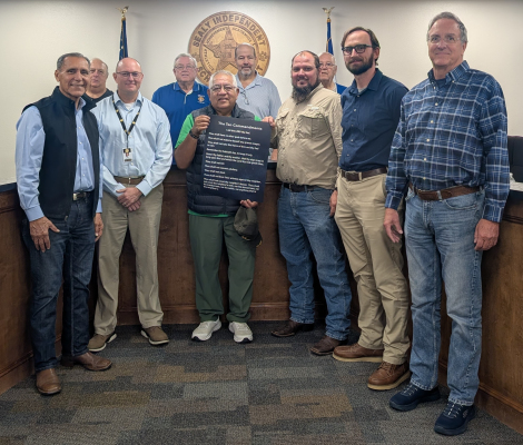 Sealy ISD Superintendent Dr. Bryan Hallmark accepts a presentation of donated Ten Commandments posters from Grace Fellowship Church and the Sealy Knights of Columbus. Pictured: (front) Grace Fellowship Church pastor Tony Romas, Sealy ISD Superintendent Dr. Bryan Hallmark, Joe Lemos (holding a copy), Dustin Konesheck, Grand Knight Travis Doucett, Mark Nastoupil, (back) Edward Klecka, past Grand Knight Robert Kent, Grace Fellowship Church member Ralph Bonds and KC Financial Secretary Joe Marusik.