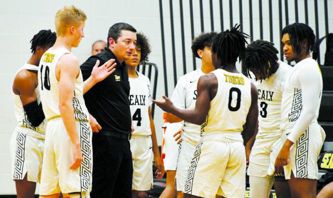 Sealy Head Boys Basketball Coach Austin Kilman talks with his team during a timeout of a recent game. Sealy is working on rebuilding its boys basketball program CONTRIBUTED PHOTO