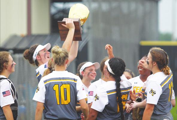 Sealy senior Avery Oliver lifts the bi-district championship trophy and celebrates with her teammates following the 24-2 win over Wheatley last Thursday at home in the first round of the playoffs. It’s the first bi-district trophy for the Lady Tigers since 2018. COLE McNANNA