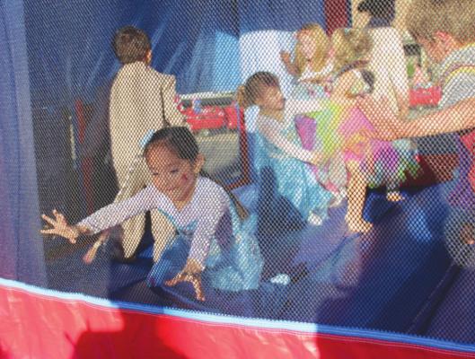 TOP: Michaela Santos struggled to stay upright while playing in the bounce house in her Elsa costume. Photo by Hans Lammeman.