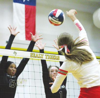 Sealy’s Jasmyne Joiner and Kenna Killough rise for a block attempt of Bellville’s Madison Morgan during the first set of the rivalry district match at Sealy High School last Friday. COLE McNANNA