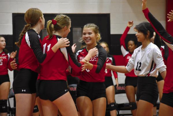 Paige Demny is congratulated after a nice play during a game earlier this season. Also pictured are Reagan Cullen (11) and Kelly McDaniel (12). COURTESY PHOTO