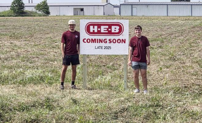 Sealy HS recent graduates Connor Wells (left) and Landen Sodolak (right) pulled off the greatest prank in Texas high school history after erecting a fake “H-E-B COMING SOON LATE 2025” sign on an empty plot of land in town. PHOTO COURTESY OF KRYSTAL KUBAN