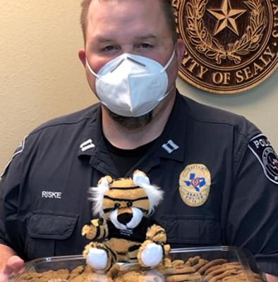 Officer Scott Riske from the Sealy Police Department receives cookies and a Sealy High School tiger for the Sealy Police Department from Brazos Valley Schools Credit Union in appreciation for all that the department does for the community. Contributed photo