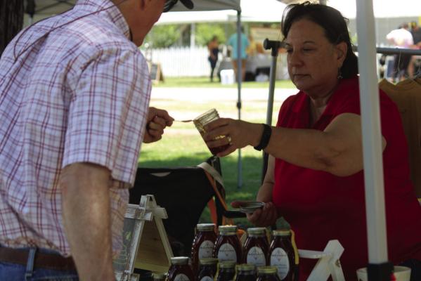 Michelle Blackburn, a honeybee farmer out of Weimar gives out a free sample of her honey at the Honey Bee Jubilee.