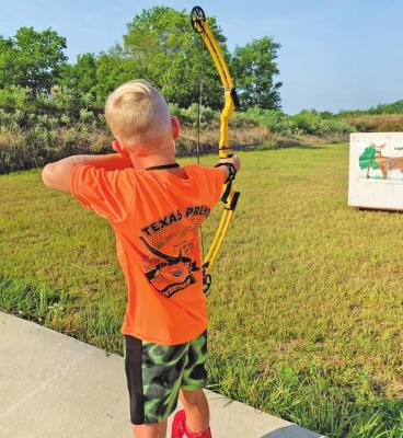 Ethan Moyer draws a bow to send an arrow into a paper-deer target during shooting camp at the Texas Premier Sporting Arms facility. CONTRIBUTED PHOTOS