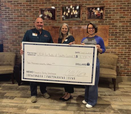 Prasek’s Clark Moffitt presents a donation from the cornhole tournament to CASA Executive Director Mandy Wright. Prasek’s held a cornhole tournament to raise funds for CASA during their anniversary celebration. Photo by Jimmy Galvan