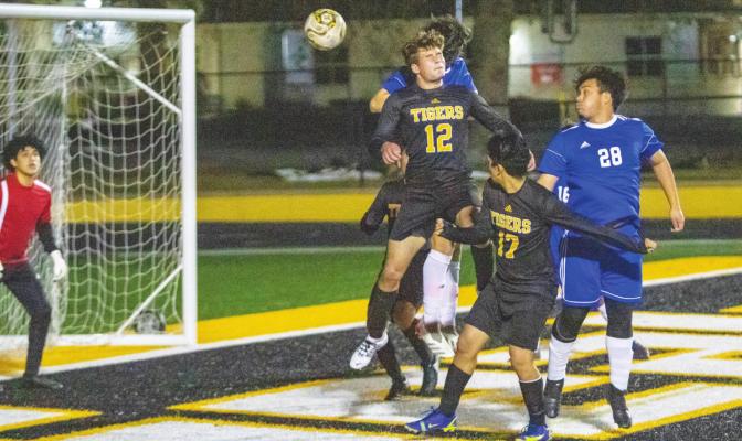 Sealy junior William Forrester leaps for a header attempt in the first half of the Tigers’ District 20 game against Discovery last Friday at T.J. Mills Stadium. Forrester provided the bookending goal in the final minutes of regulation to secure Sealy’s third straight win. COLE McNANNA