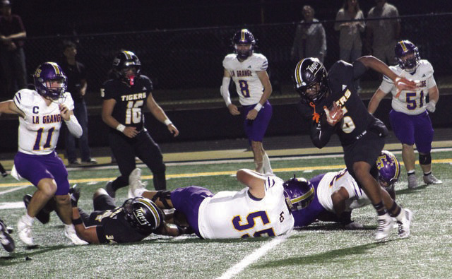 Sealy safety Javien Grant, 6, with football, helped lead Sealy’s defense in their 42-7 win over La Grange. Grant had two interceptions and here is returning one to set up a Tiger touchdown. Isaiah Dukes-Self, 34, has just made a clearing block and Jadon Hernandez, 16, is looking for someone to block.