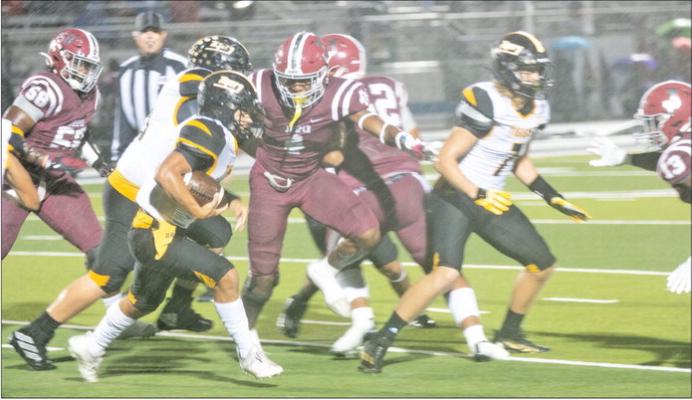 Sealy senior quarterback D’vonne Hmielewski looks for running room against Jasper during a rainy first half. Sealy defeated Jasper 31-15 to claim the bi-district title. PHOTOS BY JIMMY GALVAN
