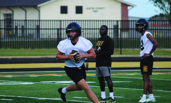 Sealy quarterback Kane Killough drops back to pass during an early practice in preparation for the upcoming season.
