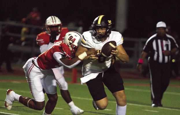 Sealy senior Reid Miller tries to avoid the rush of Bellville defensive players during last Friday’s contest. Bellville defeated Sealy as the Tigers remained winless in district play. PHOTO BY ABENEZER YONAS