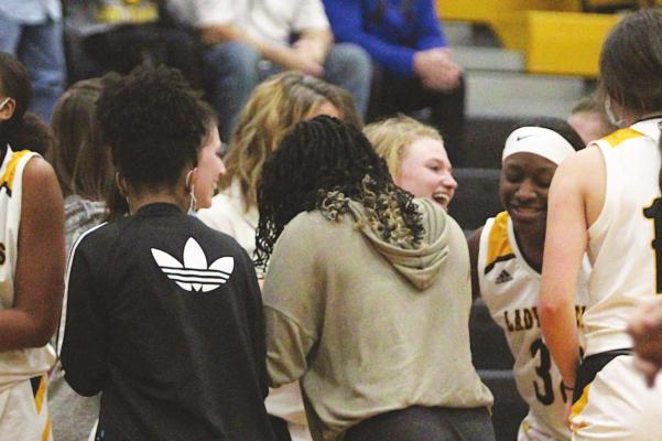 Lady Tiger senior Megan Schaaf is swarmed by teammates on the bench after supplying what ended up being the game-winning, put-back basket with less than 20 seconds to play in last Tuesday’s District 24-4A contest against Wharton at home. COLE MCNANNA