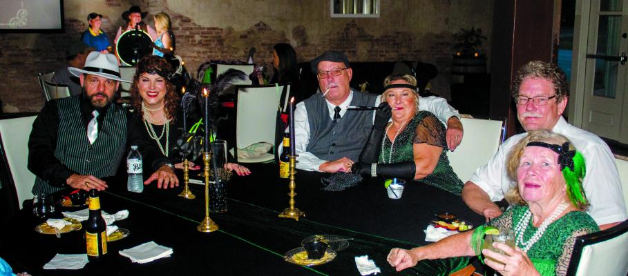 The Brandt 1910 Building in Wallis held their free Spooky Speakeasy last Saturday Oct.21 sponsored by the Fulshear-Katy Area Chamber of Commerce. The event was Prohibition themed, encouraging attendees to dress up, and featured live jazz music, food, cocktails and a costume contest. Pictured above: Cathy Holtmeier, Jim Holtmeier, Kim Patrick, Mike Patrick, Collette Terry and Horton Terry are dressed up for the occasion as they enjoy food, cocktails and music throughout the night. PHOTOS BY ABENEZER YONAS