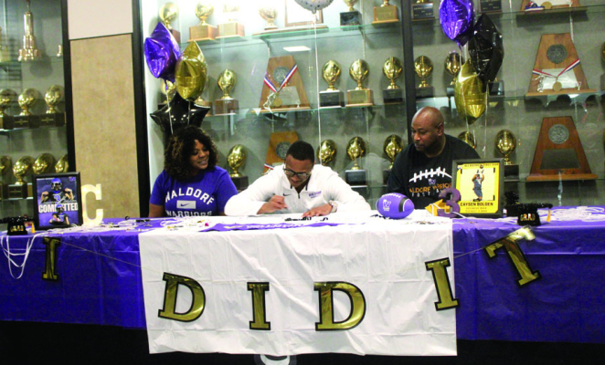 Caysen Bolden signs to commit to Waldorf University with his mother Cassie Morris (left) and his father Jason Bolden (right) by his side. SEALY NEWS | EVAN HALE