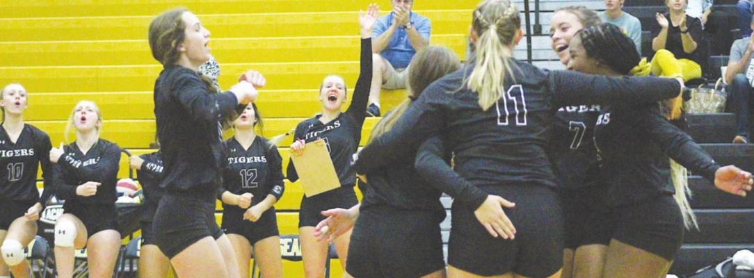 The Sealy Lady Tigers celebrate a first-set point that helped build a lead in their first district meeting with Bellville Sept. 24 at home. COLE McNANNA