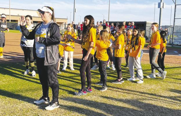 Softball buddies line up to slap hands with players as they are introduced.