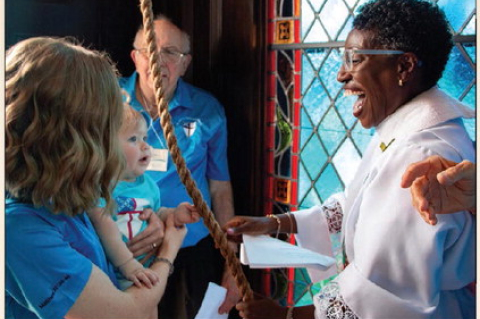 Ila Ford, the youngest member of St. John’s Episcopal Church, rings the historic bell after Wayne Hintz (back), the church’s longest serving parishioner, as part of the bell tower’s rededication ceremony, Saturday, Aug. 1, in Sealy. Ford is held by her mother Ellie Ford and helped by Rev. Rhonda Fanning. PHOTOS BY THE SEALY NEWS | ALLISON DRINNON
