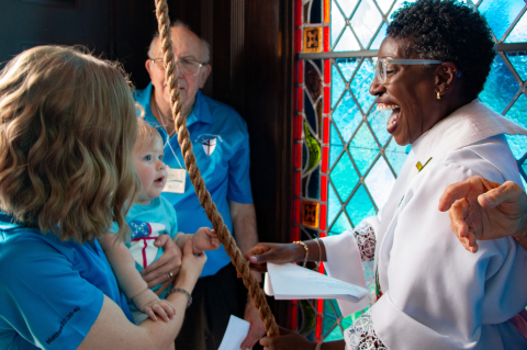 Ila Ford, the youngest member of St. John’s Episcopal Church, rings the historic bell after Wayne Hintz (back), the church’s longest serving parishioner, as part of the bell tower’s rededication ceremony, Saturday, Aug. 1, in Sealy. Ford is held by her mother Ellie Ford and helped by Rev. Rhonda Fanning. PHOTOS BY THE SEALY NEWS | ALLISON DRINNON